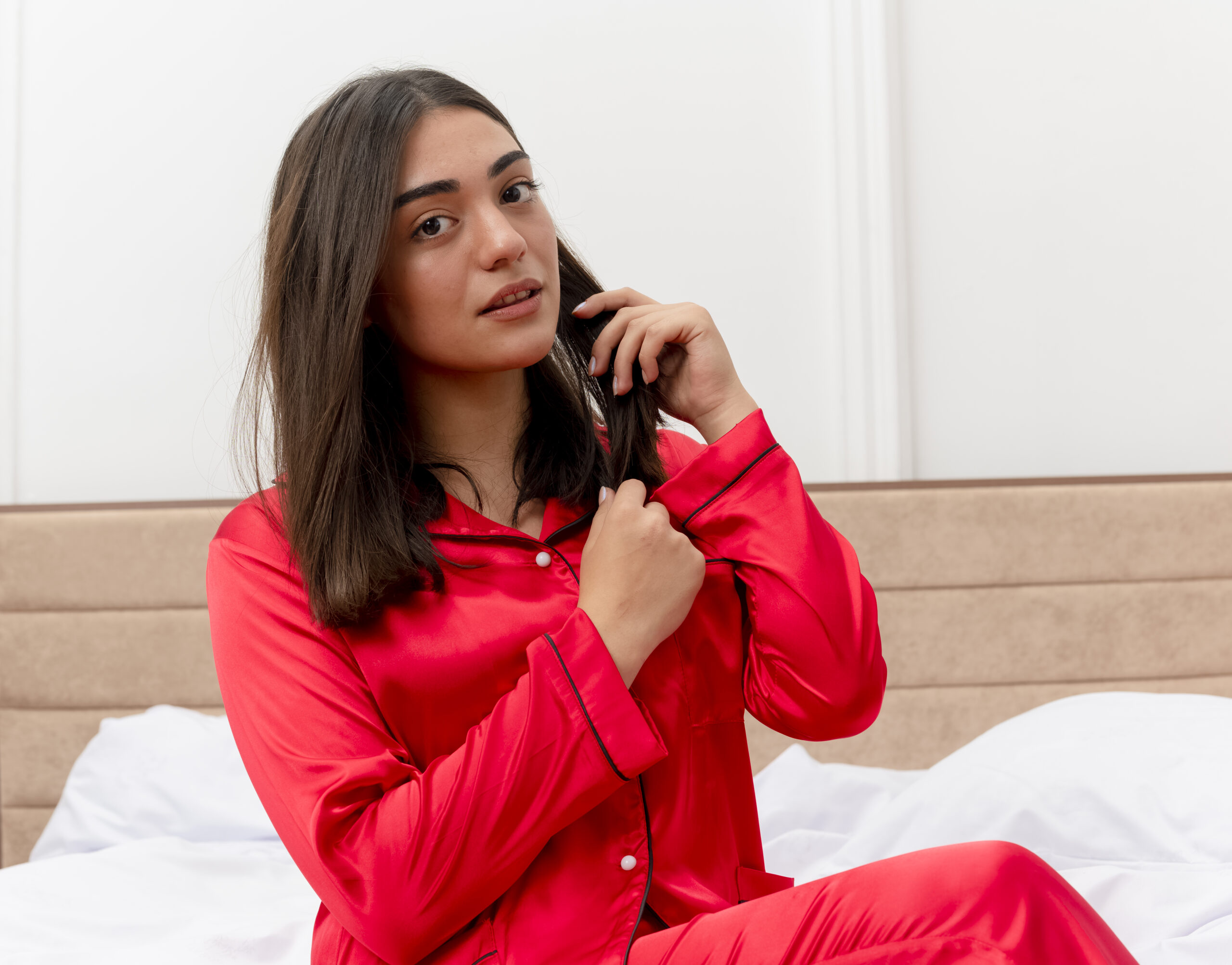 young-beautiful-woman-red-pajamas-sitting-bed-talking-mobile-phone-looking-confident-bedroom-interior-light-background